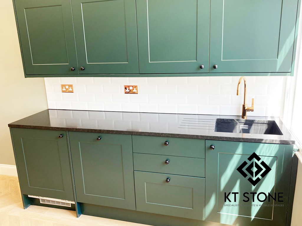 Dark quartz worktop detail with white metro-tile splashback