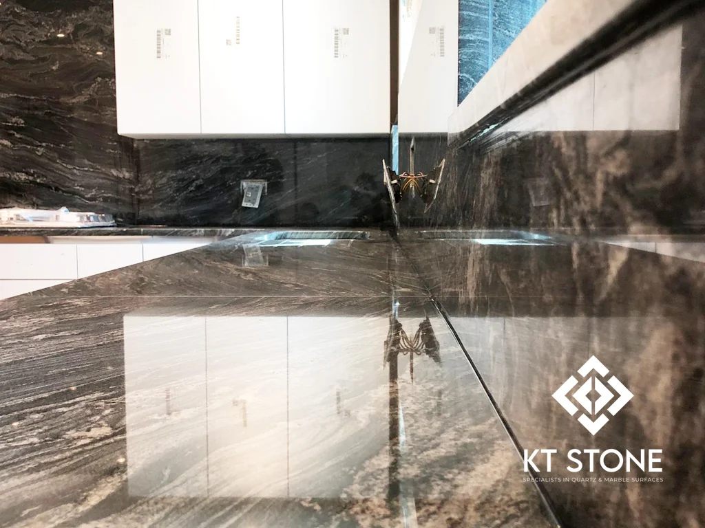 Black marble kitchen worktops with white veining and full-height splashbacks, from a KT Stone project in London.