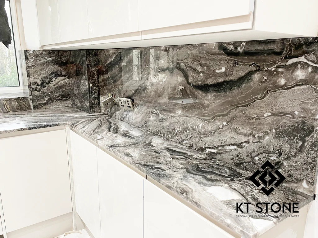 Grey veined stone worktops and full-height splashback with white cabinets, from a KT Stone project in London.
